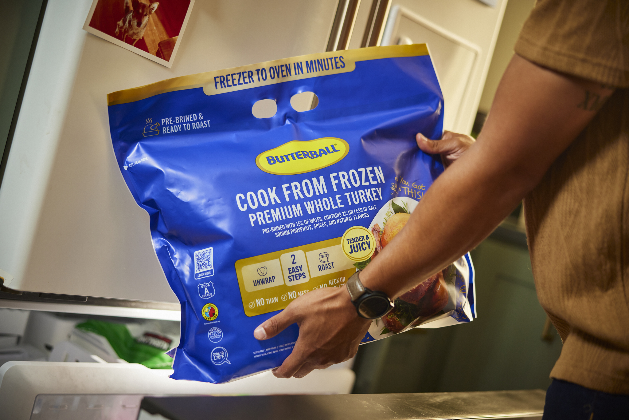A person holding a Butterball Cook from Frozen turkey package.