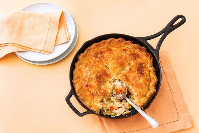 Leftover turkey recipe: a golden-brown pot pie with a flaky crust in a cast iron skillet. 