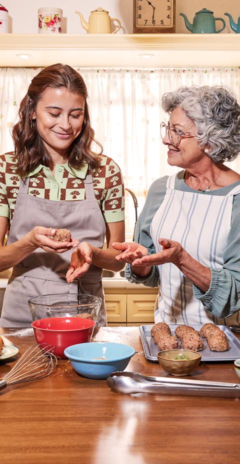 A grandma and her granddaughter in a kitchen making Butterball ground turkey meatballs