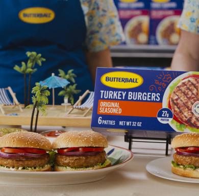 Butterball Turkey Burgers plated on a table in a grocery store. Behind them is the Butterball packaging they came in.