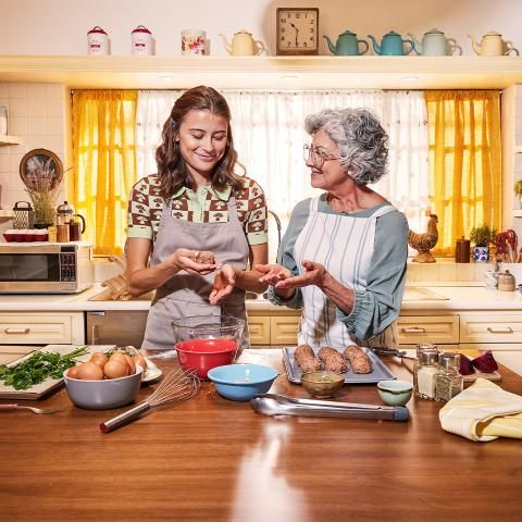 Grandmother and granddaughter preparing meatballs