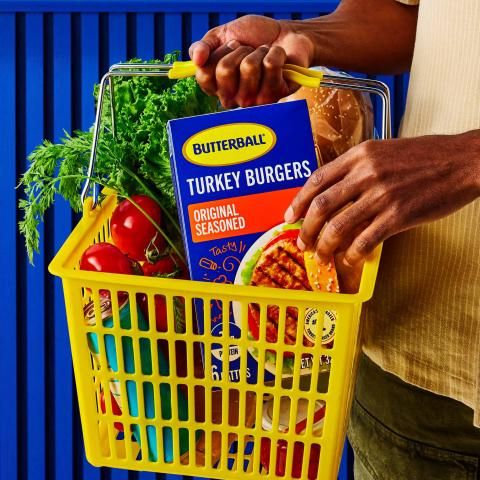 A six-patty pack of Butterball Original Seasoned Turkey Burgers in a basket of groceries.