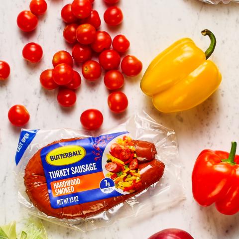 Butterball Hardwood Smoked Turkey sausage on a counter next to a variety of vegetables.