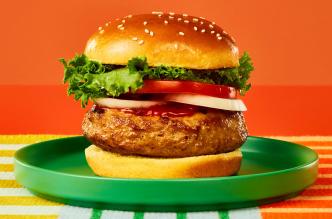 A Butterball lean ground turkey burger on a bun with lettuce, tomato, and ketchup.