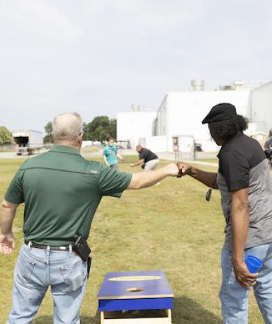 two men in a field fist bumping