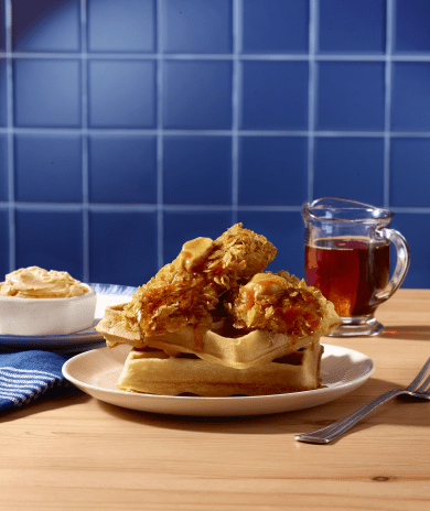 Cornflake crusted turkey tenderloin on a stack of waffles, drizzled with syrup and butter.