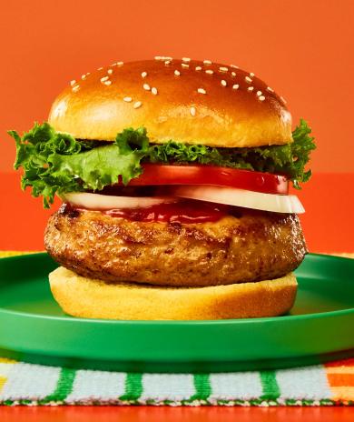 A Butterball lean ground turkey burger on a bun with lettuce, tomato, and ketchup.