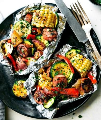 Grilled veggies and turkey sausage in foil packs with corn, zucchini, peppers, and potatoes.