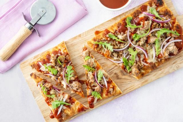 Slice of BBQ ground turkey flatbread pizza arranged on a cutting board.