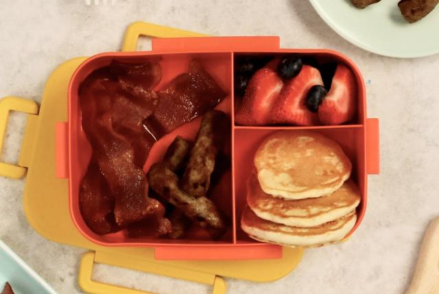 A bento box filled with breakfast foods.