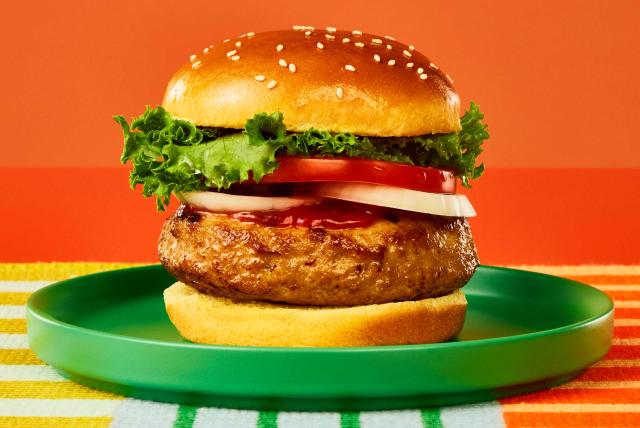 A Butterball lean ground turkey burger on a bun with lettuce, tomato, and ketchup.